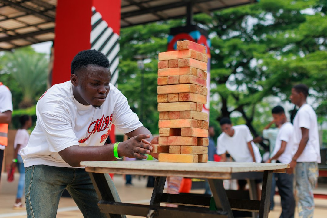 Person playing a large wooden tumbling tower game
